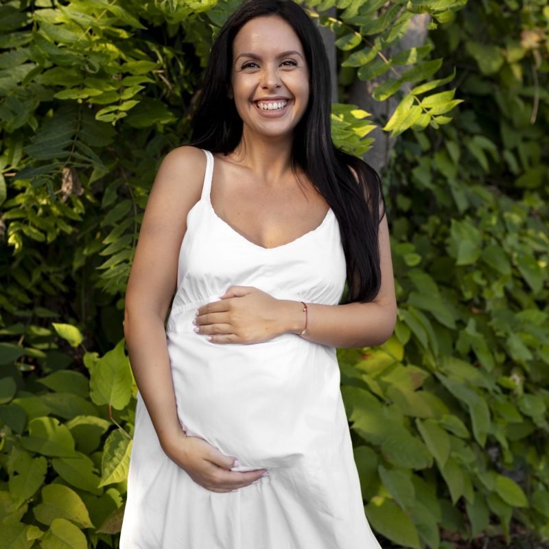 medium-shot-pregnant-woman-holding-belly